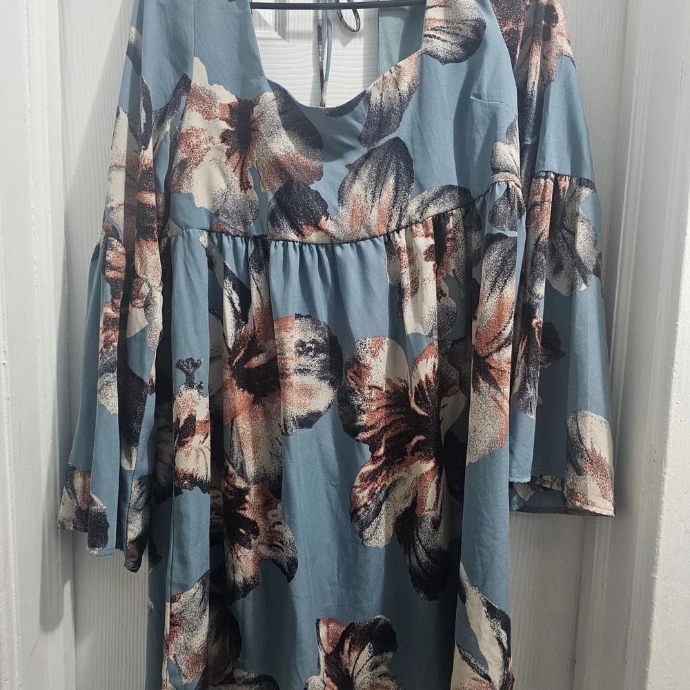 ￼

This is an Altar'd State Blue Floral Square Neck Tie Back Mini Dress - Picture 2 of 5